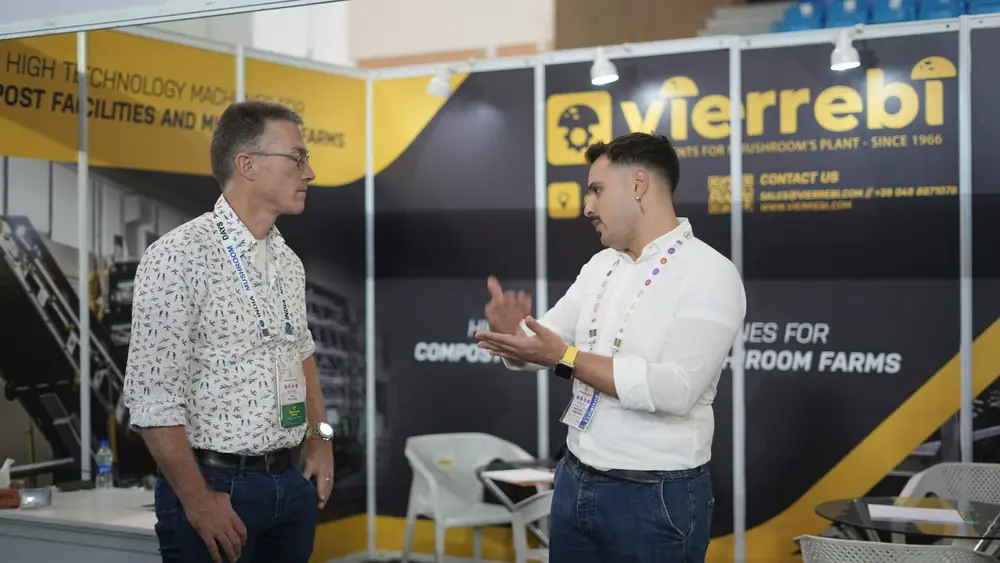 Two delegates in conversation at an equipment stand